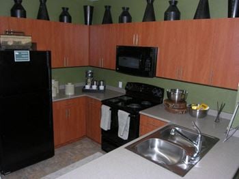 Pravada finish package-warm cherry cabinets and black appliances